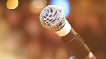 Close-up of a microphone on a stand with a blurred background.